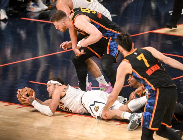 Aaron Gordon (32) of the Denver Nuggets grabs a loose ball seconds before Jamal Murray (27) calls a timeout to prevent a jump-ball situation from Isaiah Hartenstein (55) and Shai Gilgeous-Alexander (2) of the Oklahoma City Thunder during the fourth quarter of the Nuggets' 121-119 win at Paycom Center in Oklahoma City, Oklahoma on Monday, May 5, 2025. The Nuggets took a 1-0 Western Conference semifinal lead with their win. (Photo by AAron Ontiveroz/The Denver Post)