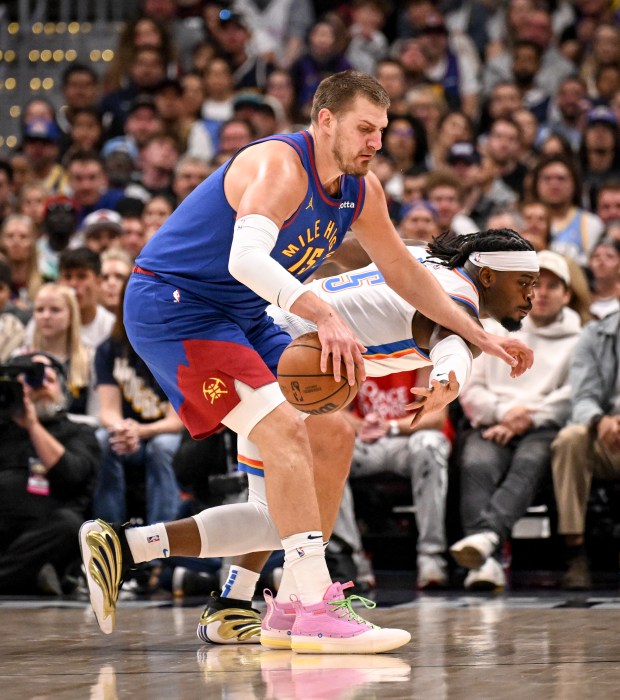 Nikola Jokic (15) of the Denver Nuggets spins around Luguentz...