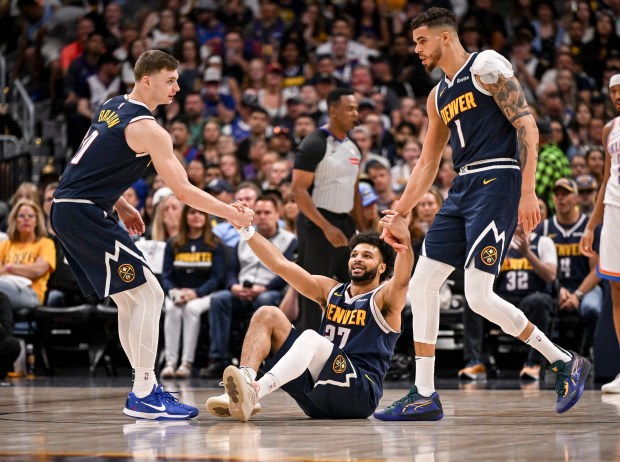 Jamal Murray (27) of the Denver Nuggets gets helped up...