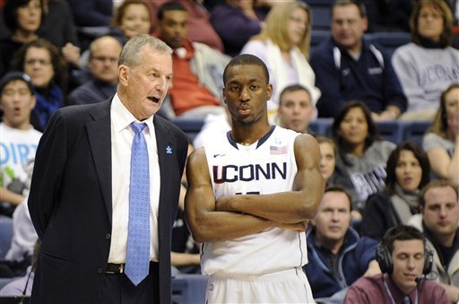 Connecticut head-coach Jim Calhoun, left, speaks with Kemba Walker late in the first half of their NCAA college basketball game against Providence in Storrs, Conn., on Sunday, Feb. 13, 2011. (AP Photo/Fred Beckham)