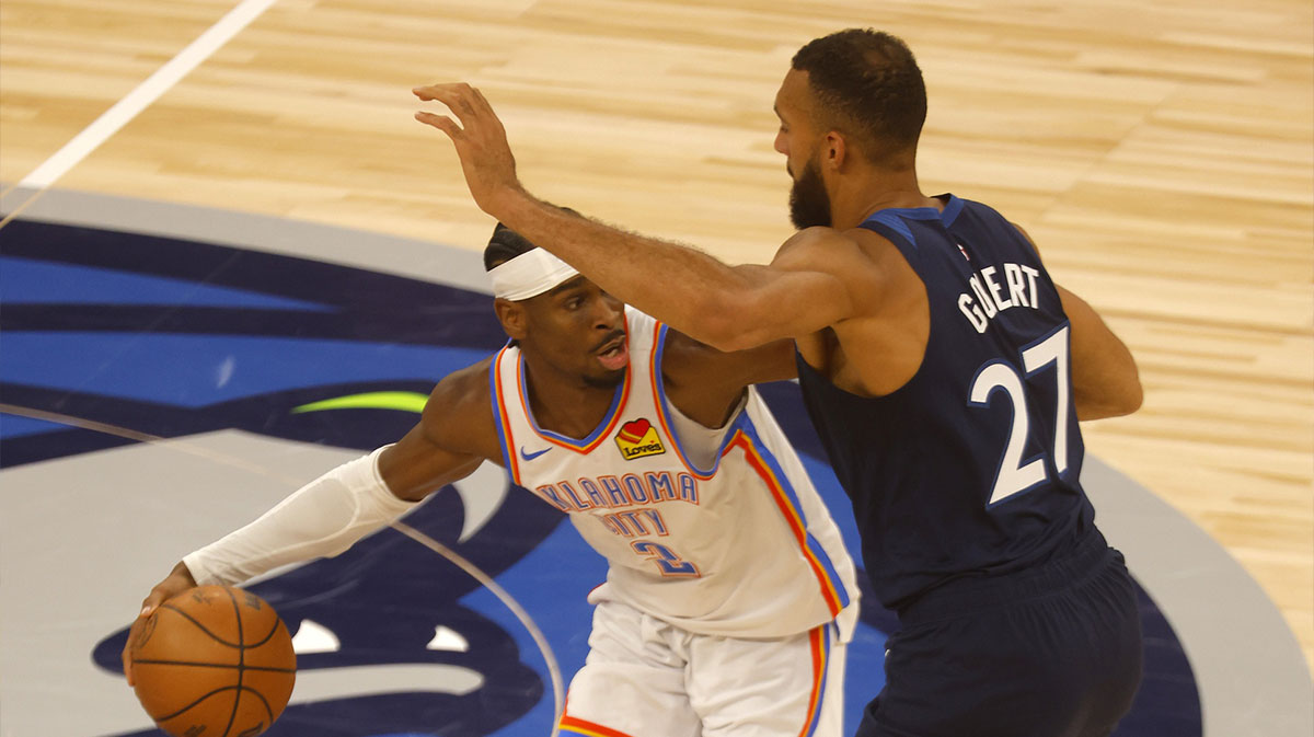 Thunder guard Shai Gilgeous-Alexander (2) dribbles the ball against Minnesota Timberwolves center Rudy Gobert (27) during the first half in game three of the western conference finals for the 2025 NBA Playoffs at Target Center