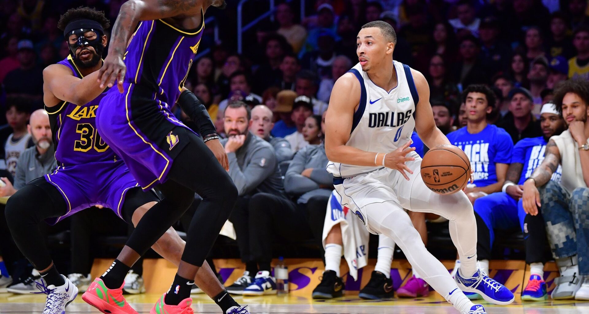 Feb 25, 2025; Los Angeles, California, USA; Dallas Mavericks guard Dante Exum (0) dribbles the ball against Los Angeles Lakers forward Dorian Finney-Smith (17) during the first half at Crypto.com Arena. Mandatory Credit: Gary A. Vasquez-Imagn Images