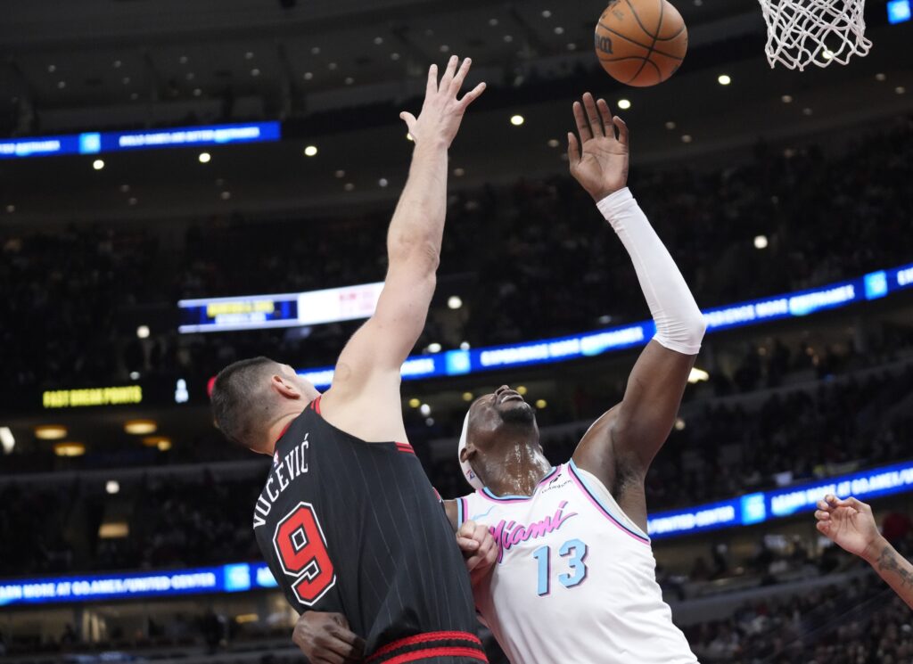 Apr 9, 2025; Chicago, Illinois, USA; Chicago Bulls center Nikola Vucevic (9) defends Miami Heat center Bam Adebayo (13) during the second half at United Center. Mandatory Credit: David Banks-Imagn Images