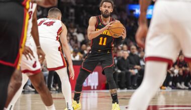Atlanta Hawks guard Trae Young (11) controls the ball against Miami Heat guard Tyler Herro (14) during the first half at State Farm Arena.