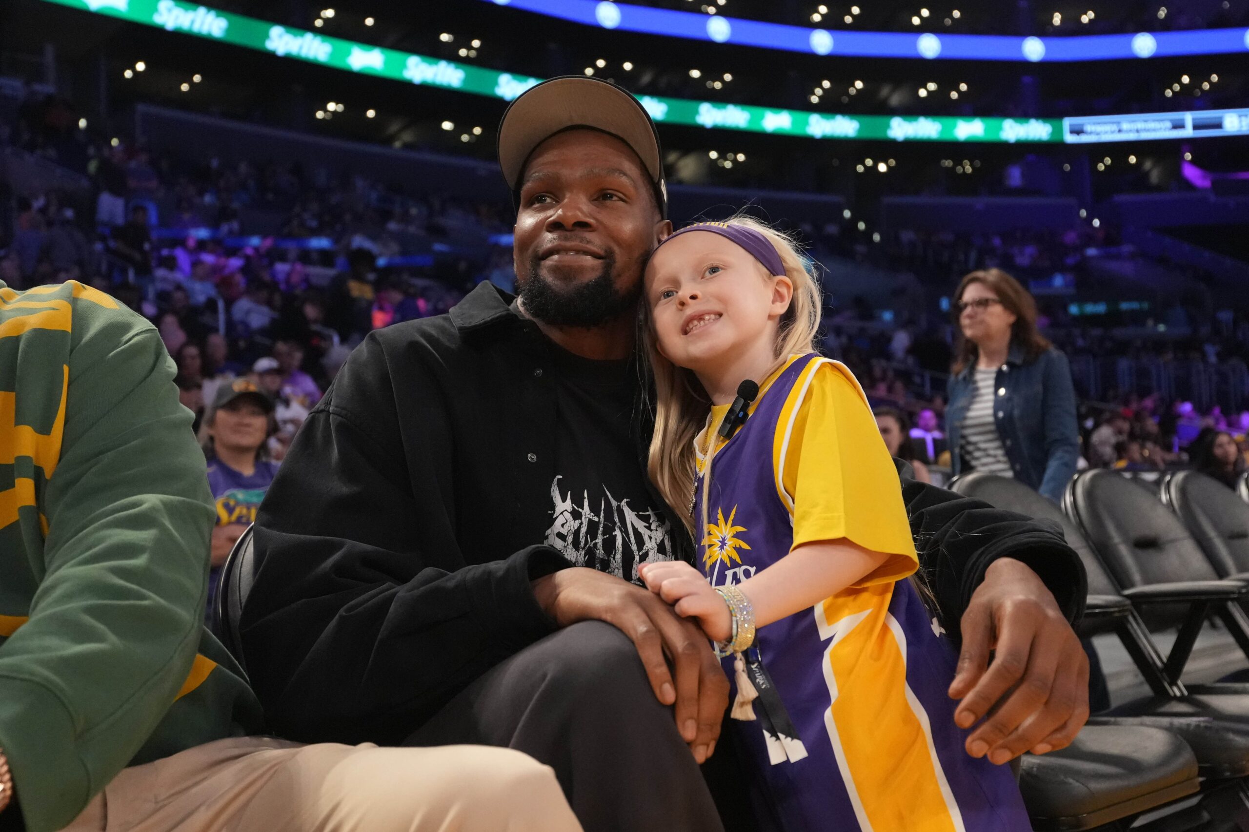 May 23, 2025; Los Angeles, California, USA; Kevin Durant poses with 8-year-old LA Sparks fan Vivian Havens during the game against the Golden State Valkyries at Crypto.com Arena.