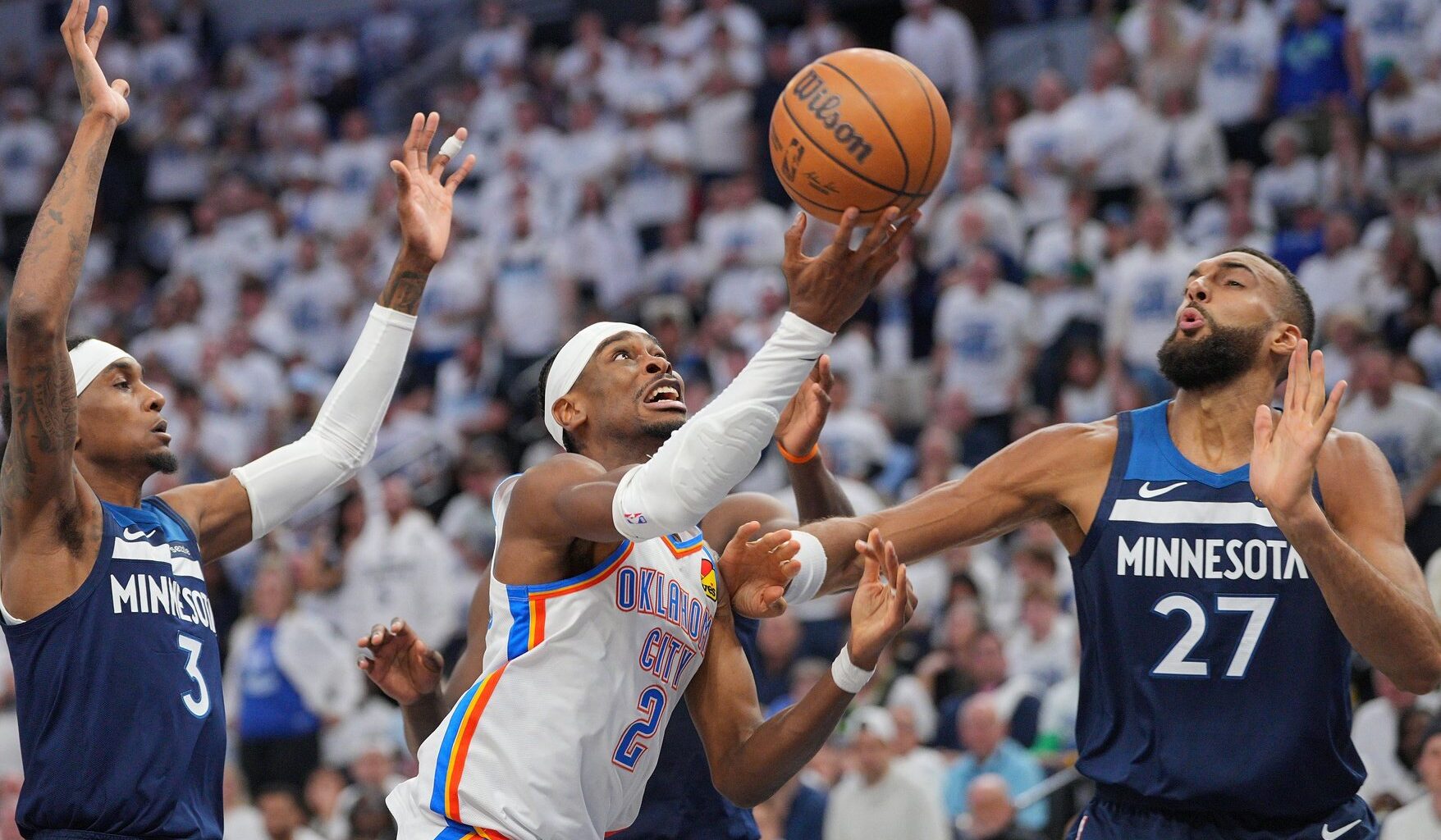 May 24, 2025; Minneapolis, Minnesota, USA; Oklahoma City Thunder guard Shai Gilgeous-Alexander (2) shoots the ball over Minnesota Timberwolves center Rudy Gobert (27) during the first half in game three of the western conference finals for the 2025 NBA Playoffs at Target Center. Mandatory Credit: Brad Rempel-Imagn Images