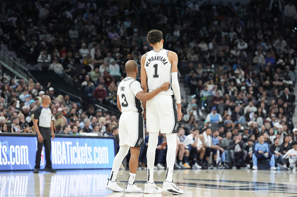 San Antonio Spurs guard Chris Paul (3) and center Victor Wembanyama (1) at midcourt during the first half against the Memphis Grizzlies at Frost Bank Center
