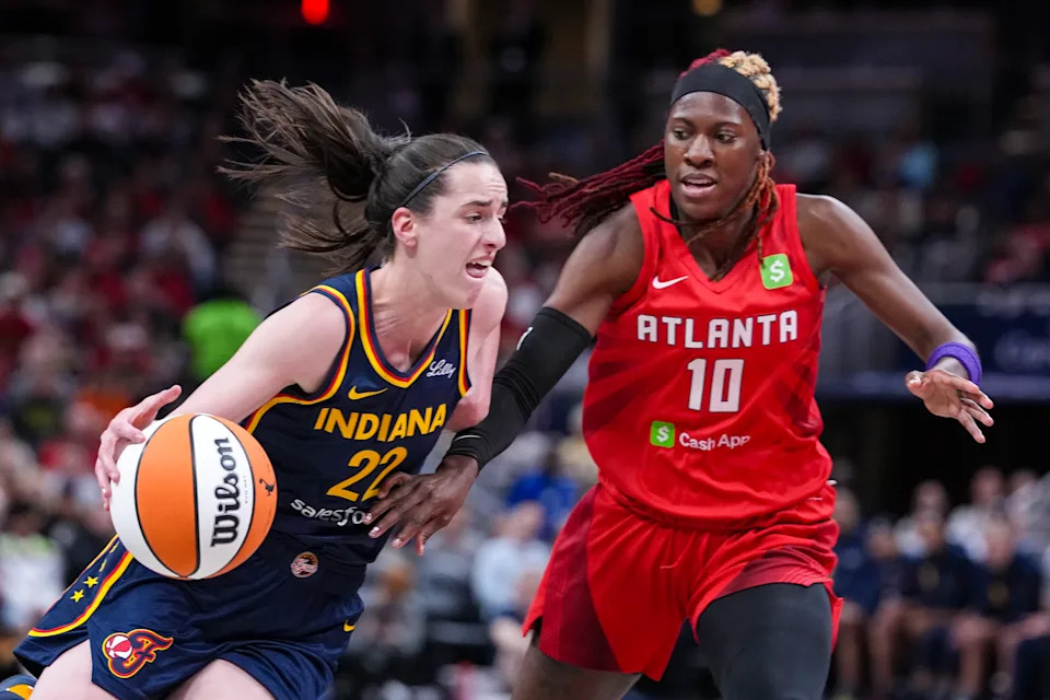 Indiana Fever guard Caitlin Clark (22) drives on Atlanta Dream guard Rhyne Howard (10) in the first half of a WNBA basketball game in Indianapolis, Tuesday, May 20, 2025. (AP Photo/Michael Conroy)