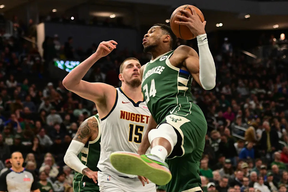 Feb 27, 2025; Milwaukee, Wisconsin, USA; Milwaukee Bucks forward Giannis Antetokounmpo (34) grabs a rebound against Denver Nuggets center Nikola Jokic (15) in the third quarter at Fiserv Forum.© Benny Sieu-Imagn Images
