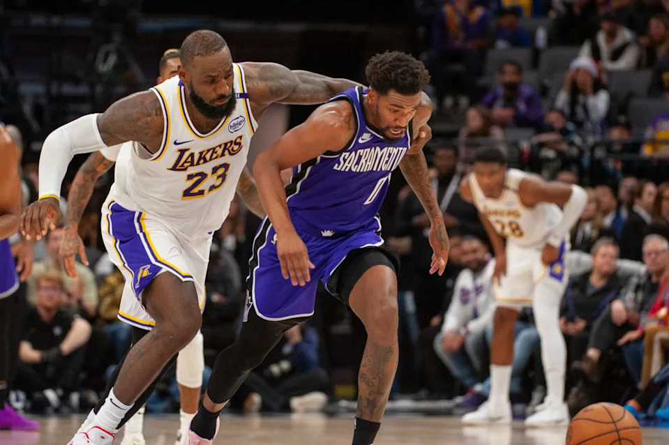 Dec 21, 2024; Sacramento, California, USA; Los Angeles Lakers forward LeBron James (23) and Sacramento Kings guard Malik Monk (0) fight for possession of the ball during the fourth quarter at Golden 1 Center. © Ed Szczepanski-Imagn Images