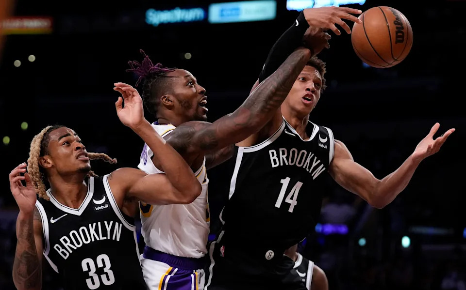 Oct 3, 2021; Los Angeles, California, USA; Los Angeles Lakers center Dwight Howard (middle) battles Brooklyn Nets forwards Nicolas Claxton (33) and Kessler Edwards (14) for a rebound in the third quarter at Staples Center. Mandatory Credit: Robert Hanashiro-USA TODAY Sports