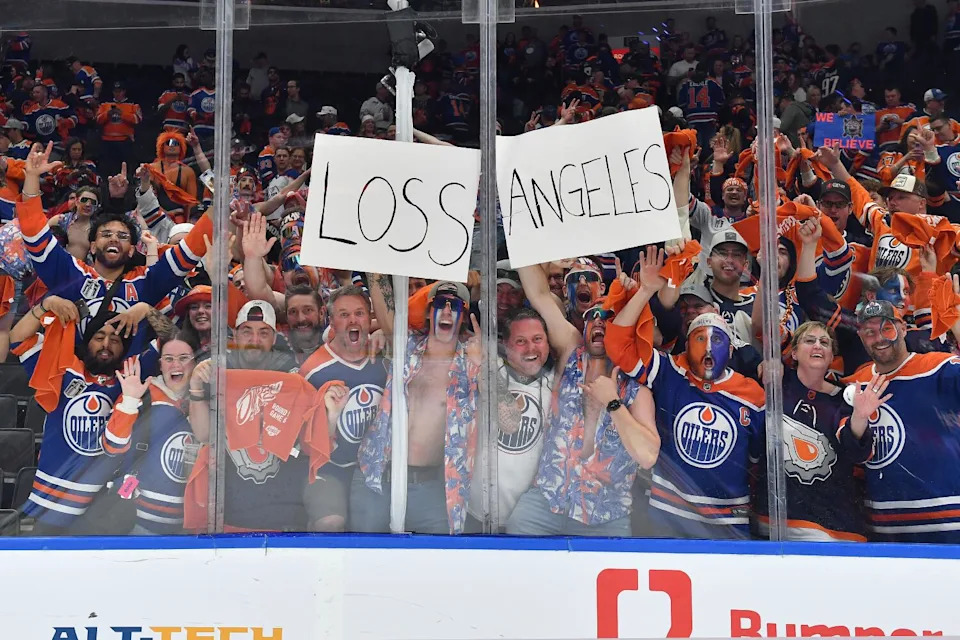 Oilers fans hold up signs that reads "Loss Angeles" as they celebrate their team's playoff series win over the Kings