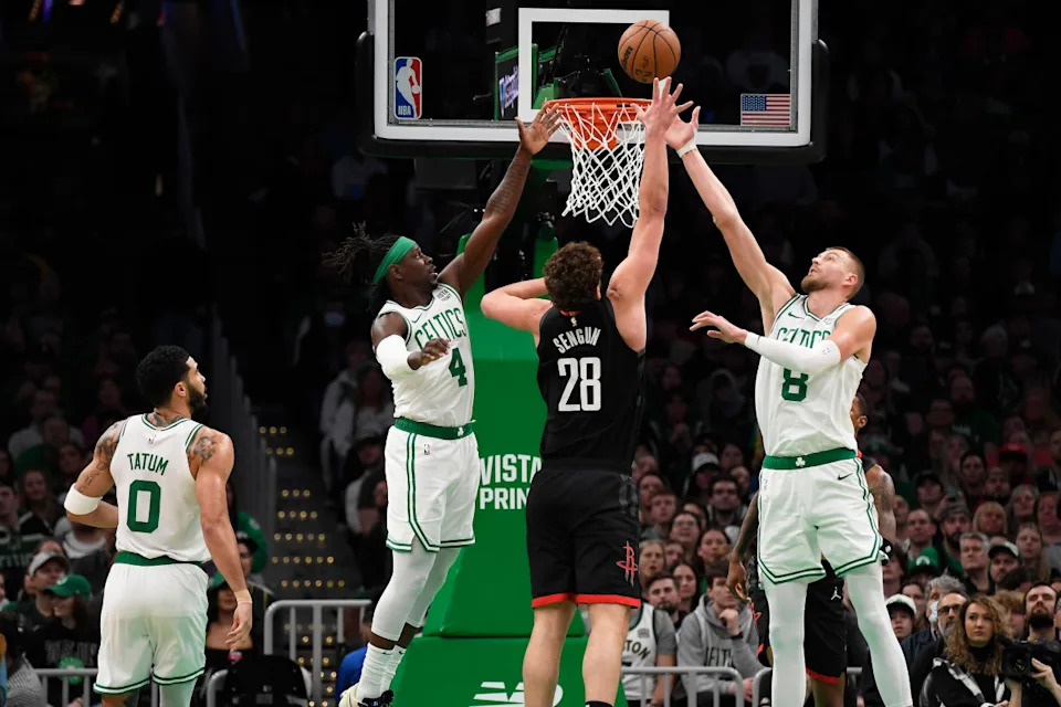 Jan 13, 2024; Boston, Massachusetts, USA; Boston Celtics guard Jrue Holiday (4) and center Kristaps Porzingis (8) and Houston Rockets center Alperen Sengun (28) battle for a rebound during the first half at TD Garden.Bob DeChiara-USA TODAY Sports