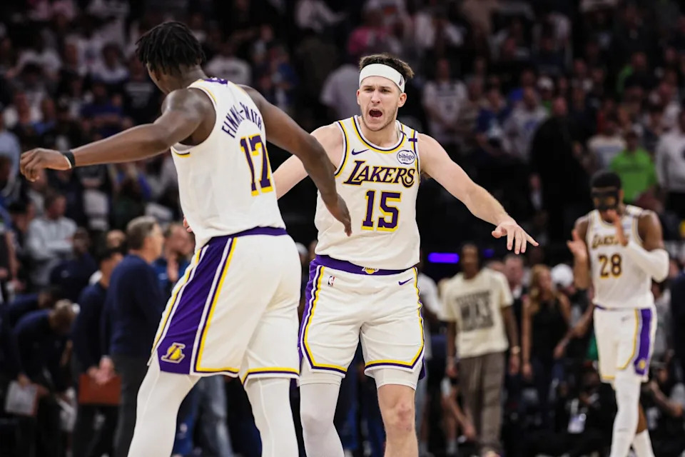 Lakers forward Dorian Finney-Smith, left, and guard Austin Reaves slap hands after Finney-Smith made a three-point shot.