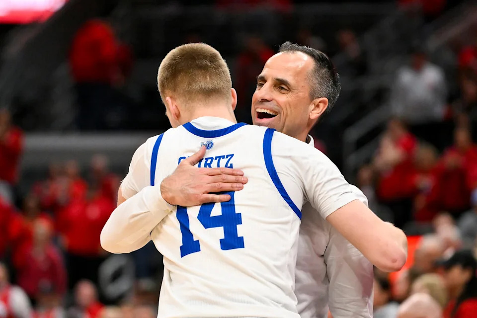 Mar 9, 2025; St. Louis, Missouri, USA; Drake Bulldogs head coach Ben McCollum hugs guard Bennett Stirtz (14) after defeating the Bradley Braves to win the Missouri Valley Conference Tournament Championship at Enterprise Center. Mandatory Credit: Jeff Curry-Imagn Images