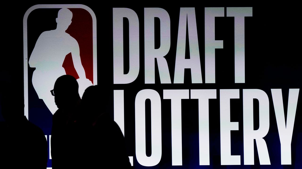 People walk by a sign during the NBA basketball draft lottery in Chicago, Tuesday, May 16, 2023.