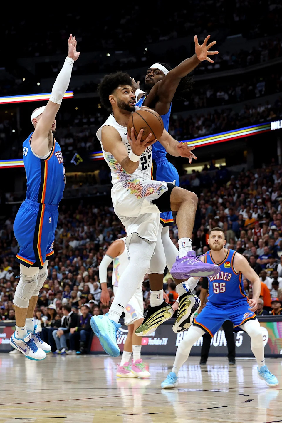 DENVER, COLORADO - MAY 15: Jamal Murray #27 of the Denver Nuggets drives to the basket between Alex Caruso #9 and Shai Gilgeous-Alexander #2 of the Oklahoma City Thunder during the first quarter in Game Six of the Western Conference Second Round NBA Playoffs at Ball Arena on May 15, 2025 in Denver, Colorado.