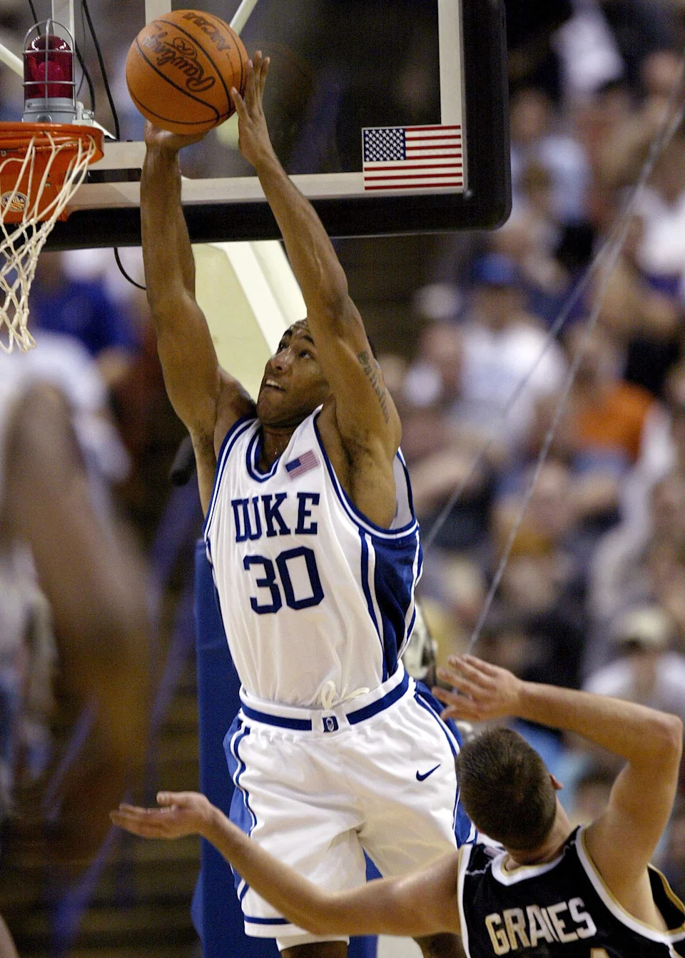 Dahntay Jones dunks over David Graves of Notre Dame.