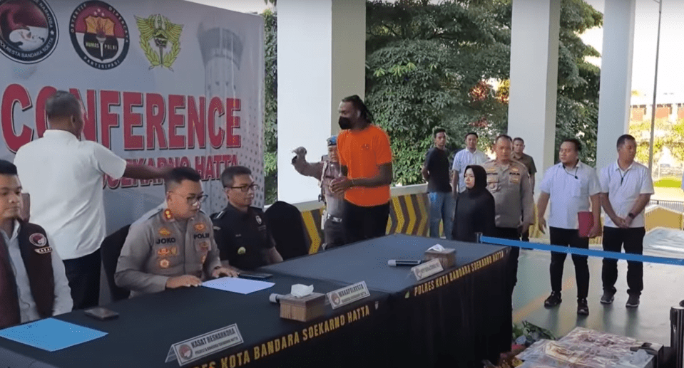 Press conference with police officers and a suspect.