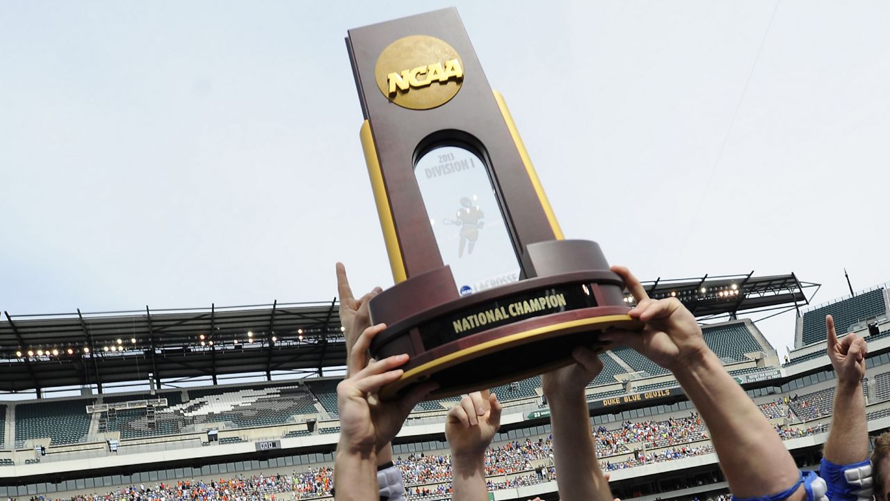 players hold ncaa national championship trophy aloft at lincoln financial field in philadelphia