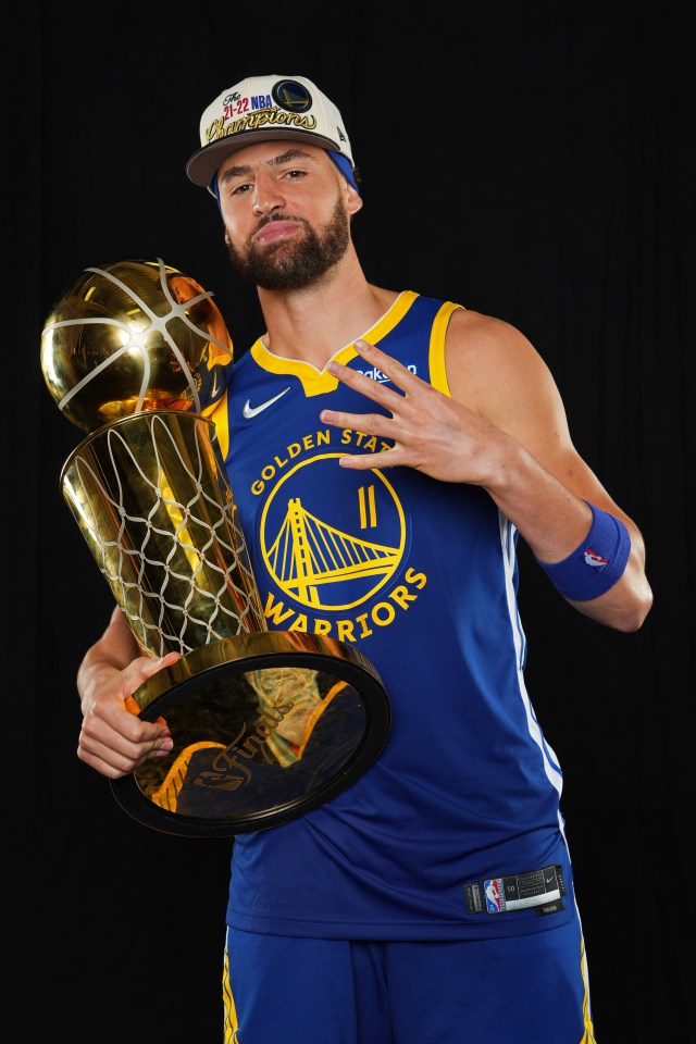 Klay Thompson of the Golden State Warriors holding the Larry O'Brien NBA Championship Trophy.
