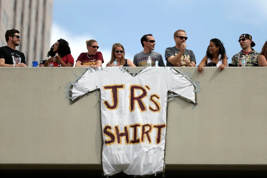 Fans look on from a parking garage near a sign reading “J.R.’s Shirt” during the Cleveland Cavaliers 2016 NBA Championship victory parade and rally on June 22, 2016 in Cleveland, Ohio. (Photo by Mike Lawrie/Getty Images)