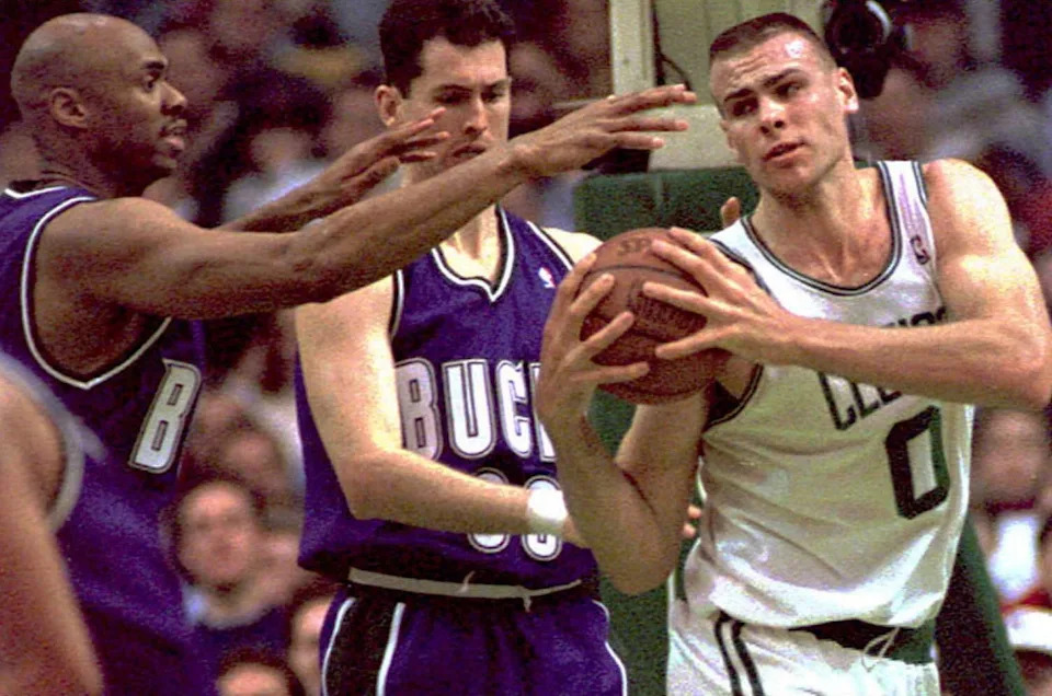BOSTON, : Boston Celtics Eric Montross (R) evades the reach of Milwaukee Bucks Vin Baker (L) as the Bucks Marty Conlon (C) looks on 03 March at the Boston Garden. The Celtics won 103-91. (COLOR KEY: Bucks wear purple.) AFP PHOTO (Photo credit should read JOHN MOTTERN/AFP via Getty Images)