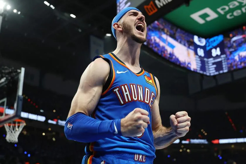 Alex Caruso, wearing a light blue headband, clenches his fists and lets out a yell during the fourth quarter of Game 7