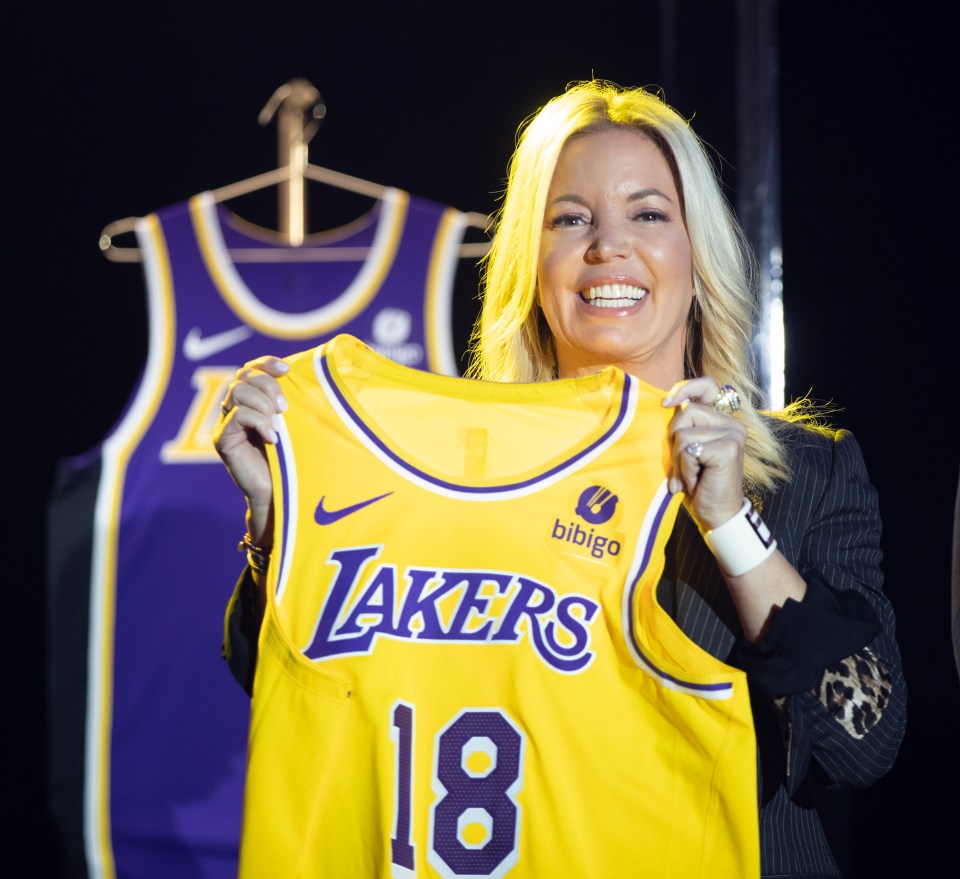 Jeanie Buss holding a new Los Angeles Lakers jersey with a Bibigo logo.
