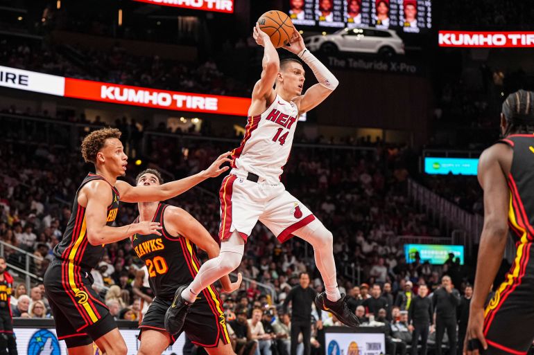 Apr 18, 2025; Atlanta, Georgia, USA; Miami Heat guard Tyler Herro (14) passes behind Atlanta Hawks guard Dyson Daniels (5) during the second half at State Farm Arena. Mandatory Credit: Dale Zanine-Imagn Images