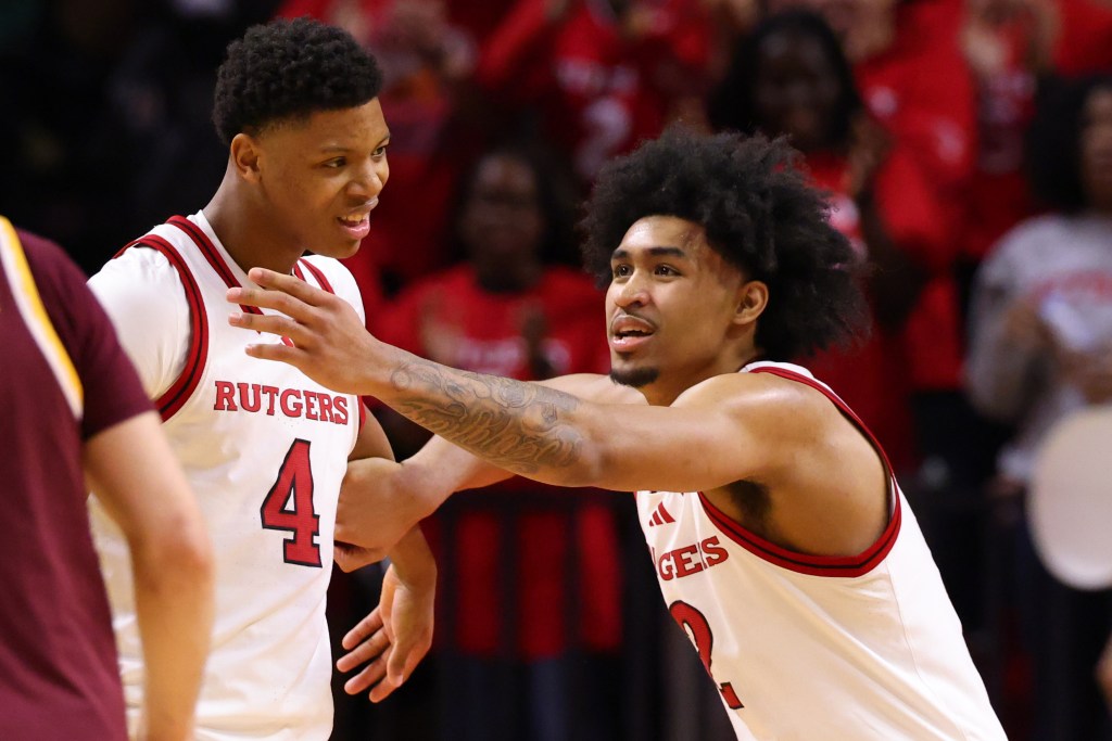 Two Rutgers basketball players celebrating.
