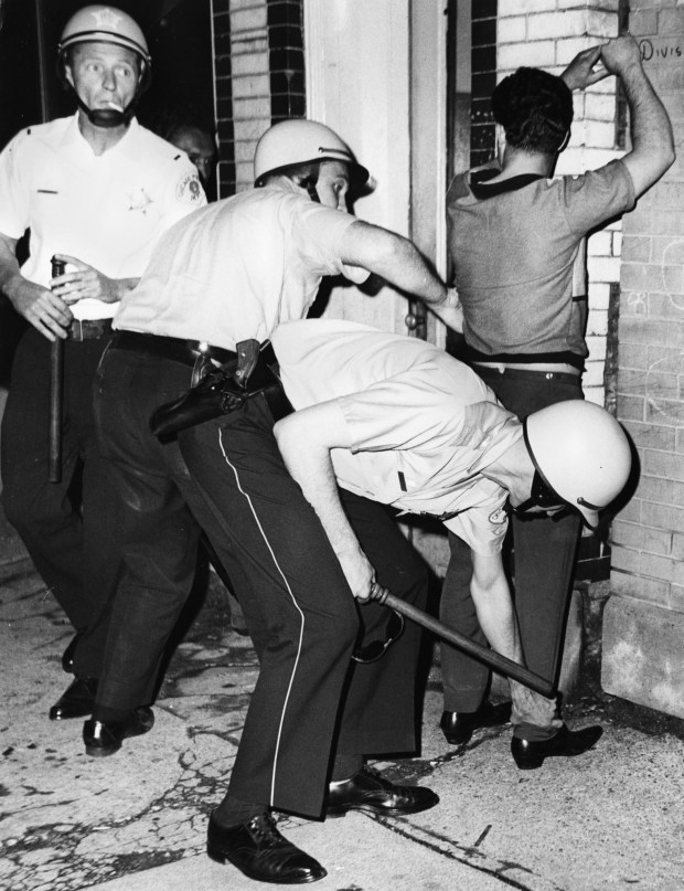 Police search a man during a flareup of violence on...