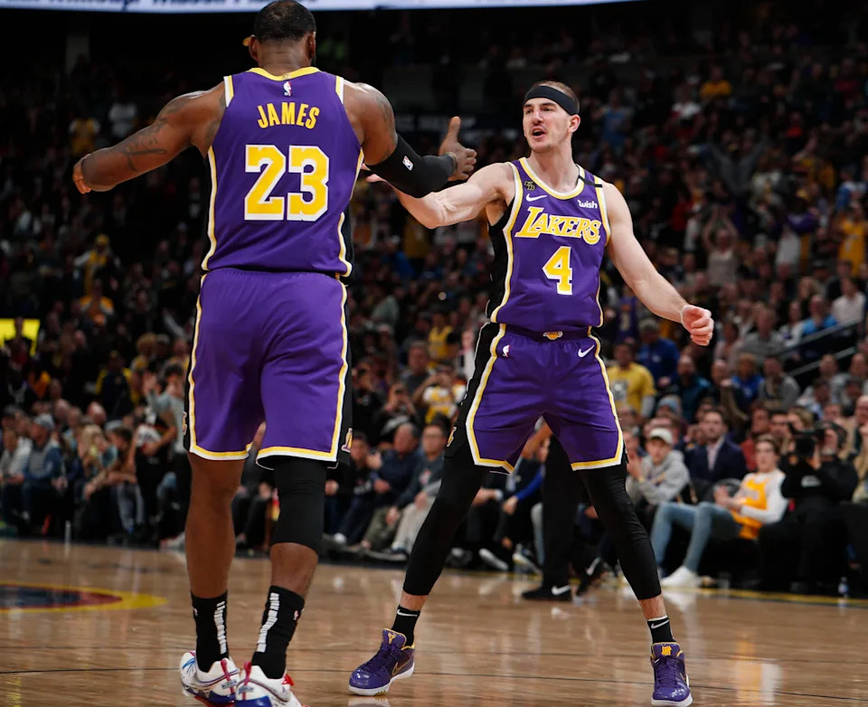 Los Angeles Lakers forward LeBron James, left, congratulates guard Alex Caruso after he scored a basket late in the second half of an NBA basketball game, Wednesday, Feb. 12, 2020, in Denver. The Lakers won 120-116 in overtime. (AP Photo/David Zalubowski)
