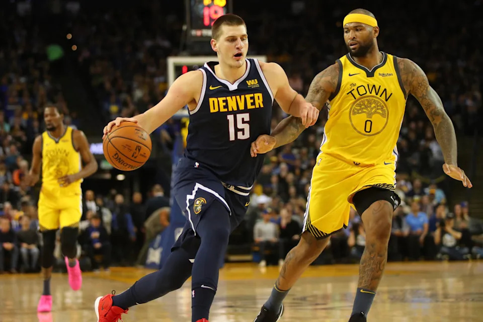 Mar 8, 2019; Oakland, CA, USA; Denver Nuggets center Nikola Jokic (15) attempts to dribble past Golden State Warriors center DeMarcus Cousins (0) in the third quarter at Oracle Arena.© Cary Edmondson-Imagn Images