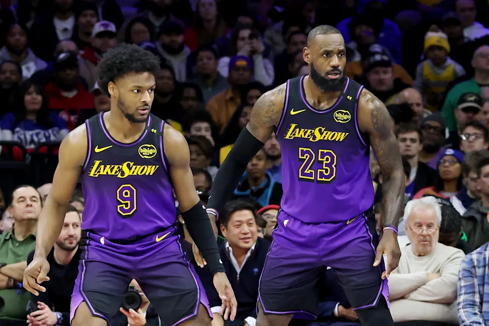 Bronny James stands next to LeBron James during the second half of a Lakers game at the Philadelphia 76ers, Jan. 28, 2025.