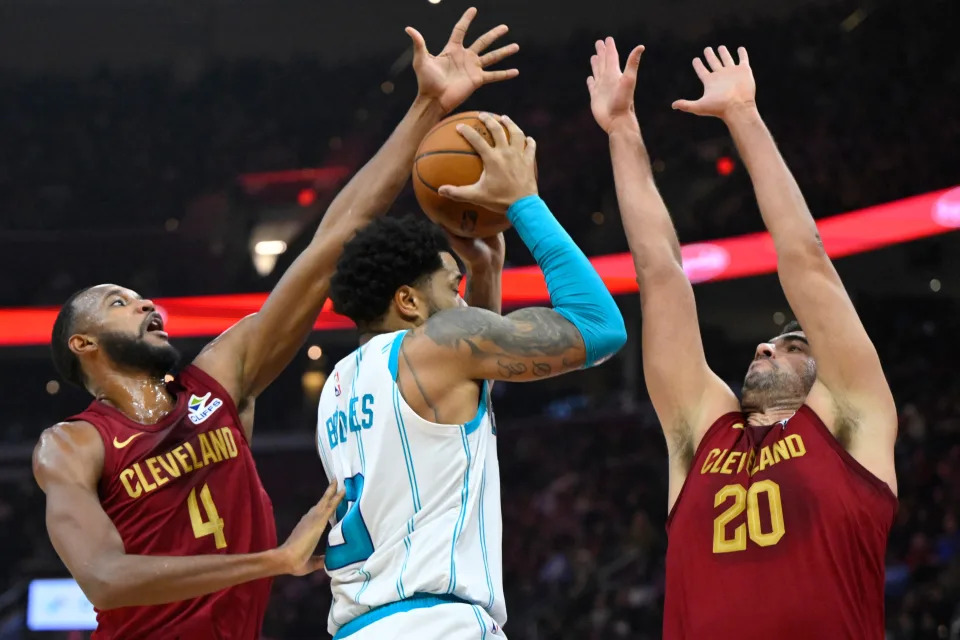 Hornets forward Miles Bridges drives between Cavaliers forwards Evan Mobley (4) and forward Georges Niang in the second quarter, Jan. 5, 2025, in Cleveland.