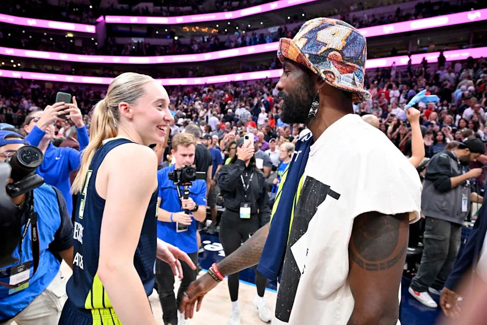 Dallas Mavericks point guard Kyrie Irving talks with Dallas Wings guard Paige Bueckers (5) after the game against the Indiana Fever at the American Airlines Center.© Jerome Miron-Imagn Images