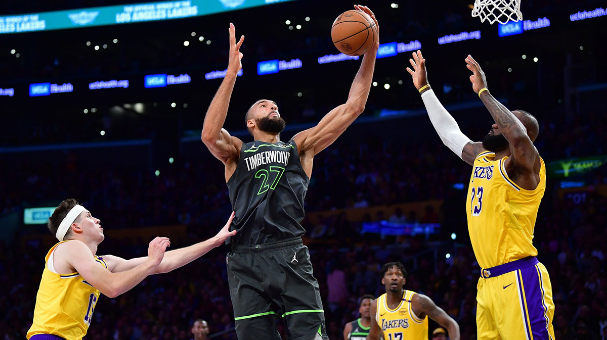 Minnesota Timberwolves center Rudy Gobert (27) gets the rebound against Los Angeles Lakers guard Austin Reaves (15) and forward LeBron James (23) during the second half in game five of first round for the 2025 NBA Playoffs at Crypto.com Arena. 