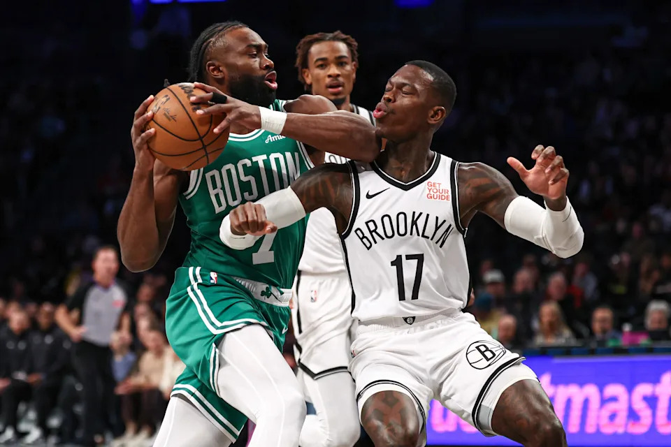 Nov 13, 2024; Brooklyn, New York, USA; Boston Celtics guard Jaylen Brown (7) drives to the basket as Brooklyn Nets guard Dennis Schroder (17) defends during the first quarter at Barclays Center. Mandatory Credit: Vincent Carchietta-Imagn Images