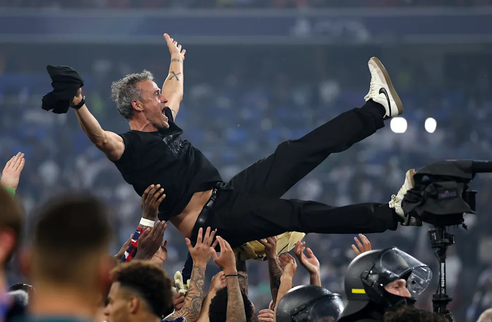 PSG manager Luis Enrique is hoisted into the air by his players. (Lars Baron/Getty Images)