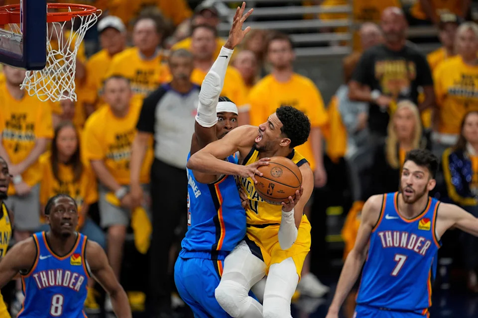 Indiana Pacers guard Tyrese Haliburton shoots around Oklahoma City Thunder guard Shai Gilgeous-Alexander, left, during the second half of Game 3 of the NBA Finals basketball series, Wednesday, June 11, 2025, in Indianapolis. (AP Photo/Abbie Parr)