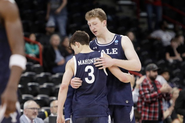 Yale guard August Mahoney (3) hugs forward Danny Wolf while leaving the game during the second half of a second-round college basketball game against San Diego State in the NCAA Tournament in Spokane, Wash., Sunday, March 24, 2024. (AP Photo/Young Kwak)