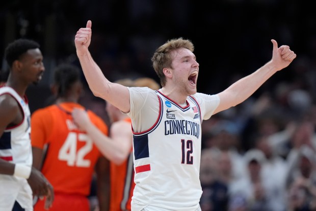 UConn guard Cam Spencer (12) celebrates during the second half of the Elite 8 college basketball game against Illinois in the men's NCAA Tournament, Saturday, March 30, 2024, in Boston. (AP Photo/Steven Senne)