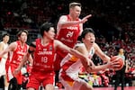 FILE - Josh Hawkinson, top, of Japan and Yudai Baba, left, guard Yang Hansen, right, of China during a Group C match of the FIBA Asia Cup 2025 qualifier match in Tokyo, Japan, Sunday, Feb. 25, 2024.