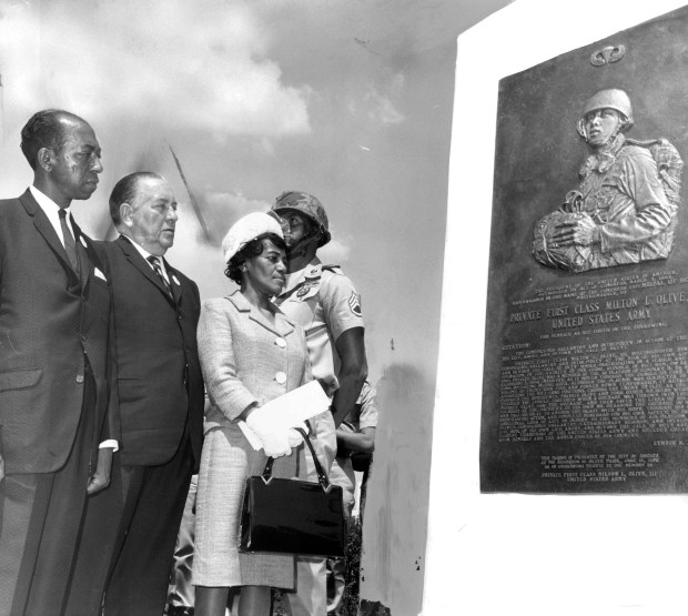 Mayor Richard J. Daley is flanked by Mr. and Mrs. Milton Lee Olive Jr., parents of the medal of honor winner, at ceremonies on June 19, 1966, unveiling the monument to the memory of Private First Class Milton Lee Olive in a park now known as Olive Park. The monument is sculpted in bronze. Editors note: this historic print has some pencil markings on it. (William Vendetta/Chicago Tribune)
