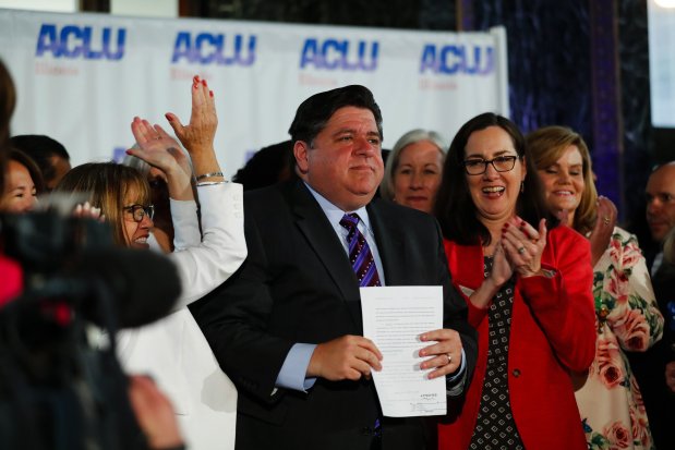 Illinois Gov. J.B. Pritzker signs the Reproductive Health Act into law at the Chicago Cultural Center on June 12, 2019, with bill sponsors Illinois state Sen. Melinda Bush, left, and Illinois state Rep. Kelly Cassidy, right. (José M. Osorio/Chicago Tribune)