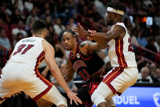 Chicago Bulls forward DeMar DeRozan (11) fends off Miami Heat forward Jimmy Butler (22) while under pressure from Heat guard Max Strus (31) during the second half of an NBA basketball play-in tournament game, Friday, April 14, 2023, in Miami. (AP Photo/Rebecca Blackwell)