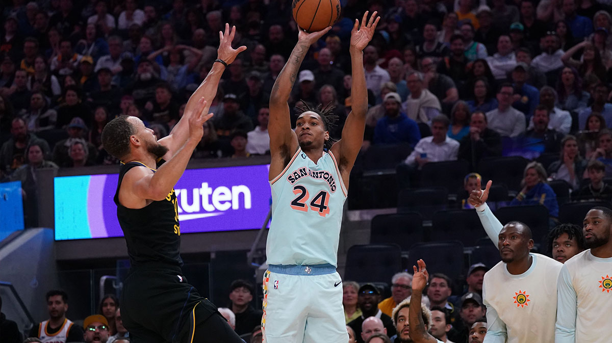 San Antonio Spurs guard-forward Devin Vassell (24) makes a three point basket over Golden State Warriors guard Stephen Curry (30) in the fourth quarter at Chase Center. 