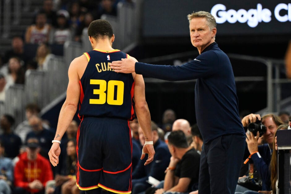Head coach Steve Kerr of the Golden State Warriors pats Stephen Curry #30 on the back.