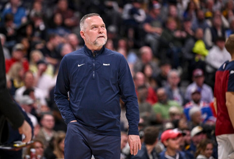 Former head coach of the Denver Nuggets, Michael Malone looks up with a hand in his pocket.